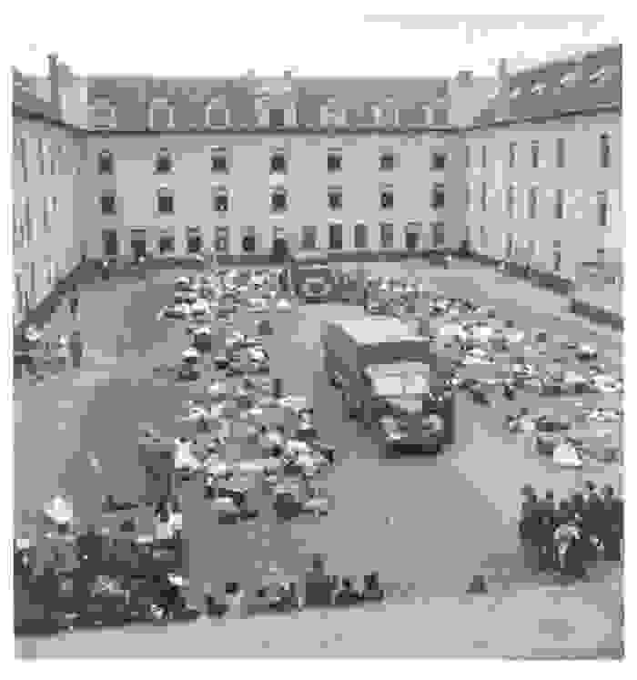 Des biens personnels jonchent la cour intérieure de la Caserne Dossin, avec au milieu un camion stationné